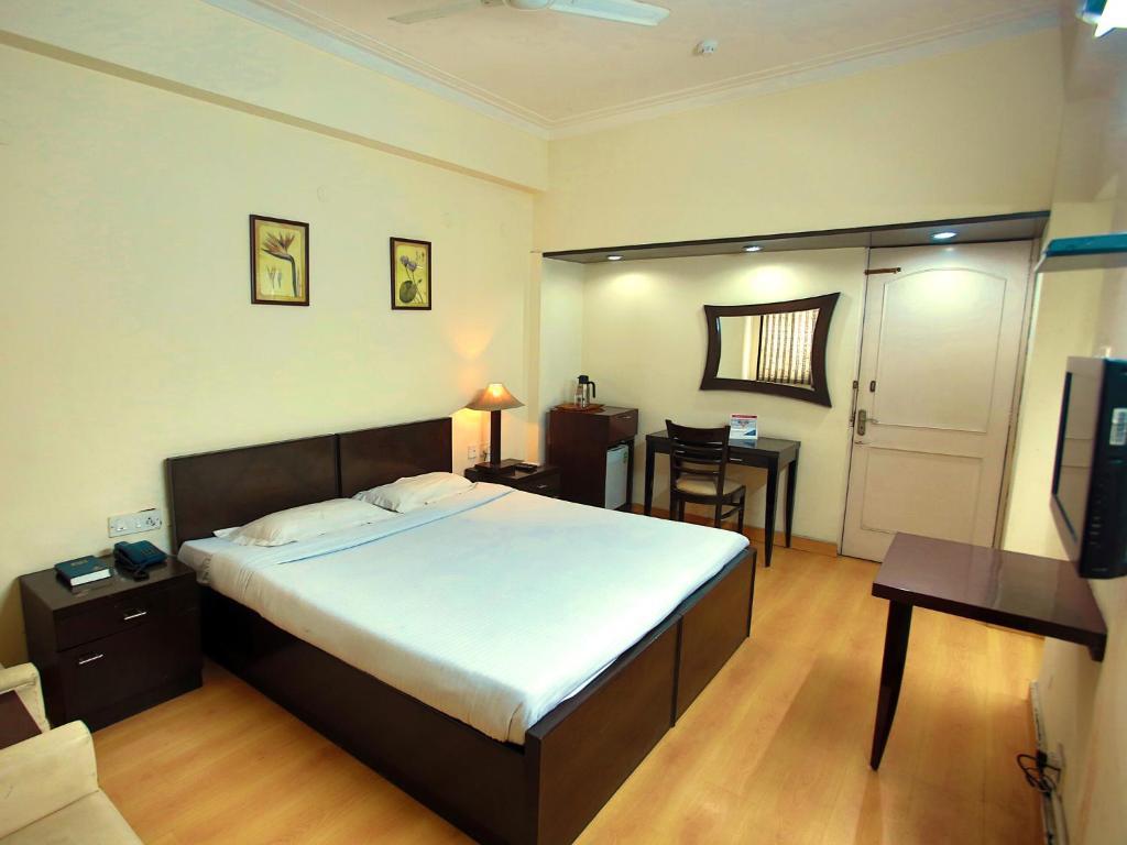 a bedroom with one chair and table at YMCA Tourist Hotel in New Delhi